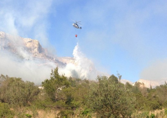 Helicopter dropping water behind our house which you can see through the trees